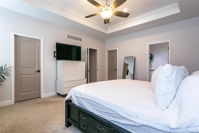 bedroom featuring a raised ceiling, visible vents, ornamental molding, light carpet, and baseboards