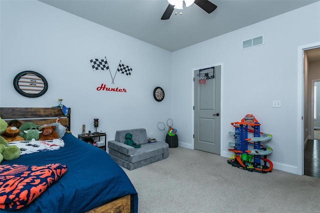 carpeted bedroom with baseboards, visible vents, and a ceiling fan