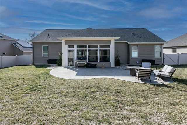 back of property with a yard, a patio area, a fenced backyard, and a sunroom