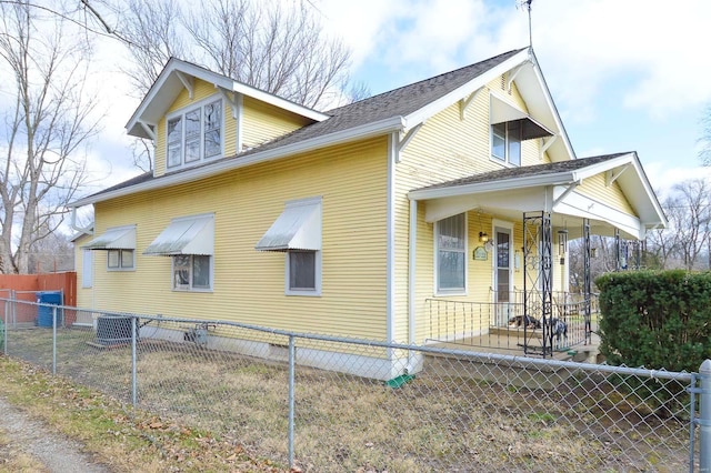 view of property exterior with a fenced front yard and roof with shingles