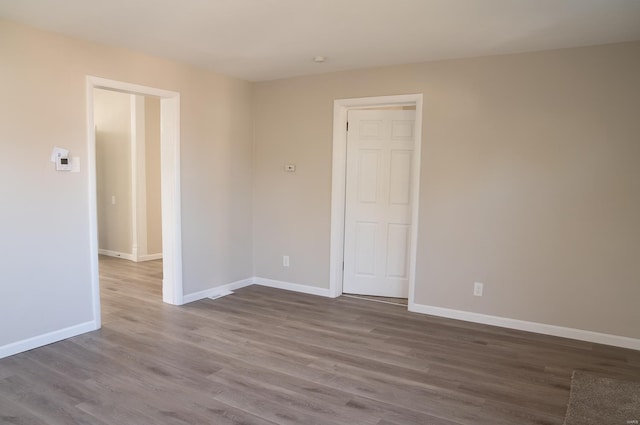 unfurnished room featuring dark wood finished floors and baseboards