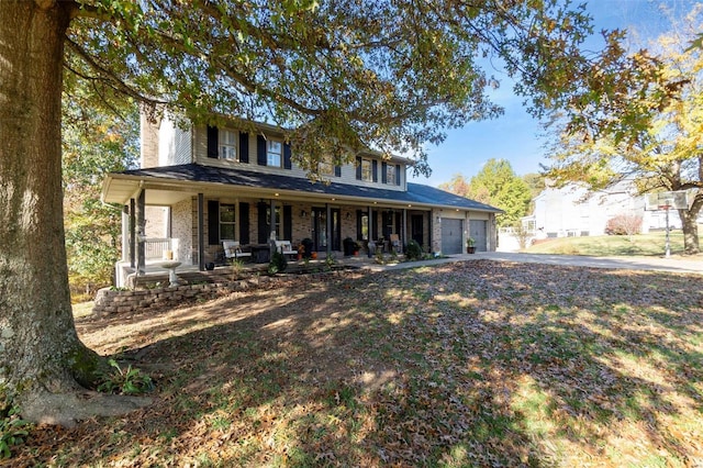 view of front of property with a garage, brick siding, covered porch, and driveway