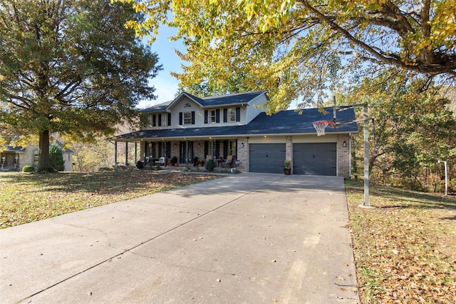 view of front of property featuring a garage, brick siding, a porch, and driveway