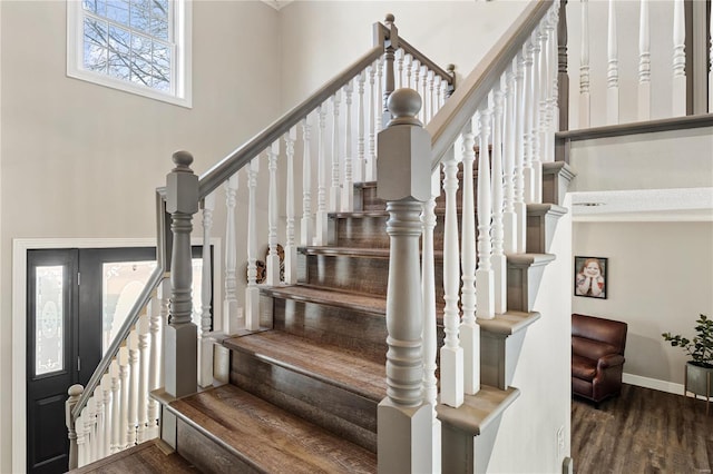 staircase with baseboards and wood finished floors