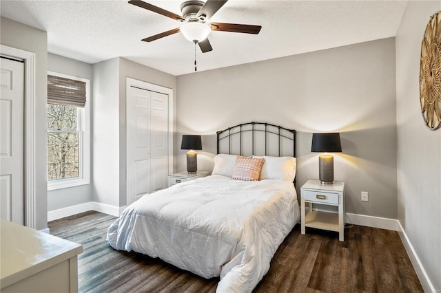 bedroom with a ceiling fan, dark wood-style floors, baseboards, and a textured ceiling