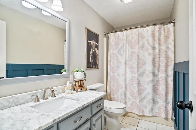 full bath with toilet, a shower with shower curtain, vanity, tile patterned floors, and a textured ceiling