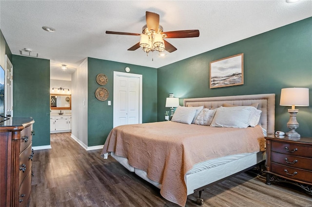 bedroom with ceiling fan, baseboards, wood finished floors, a closet, and a textured ceiling