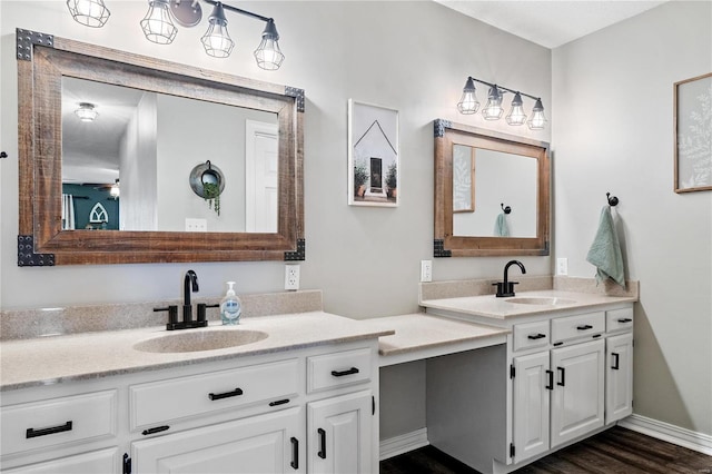 bathroom featuring a sink, two vanities, wood finished floors, and a ceiling fan