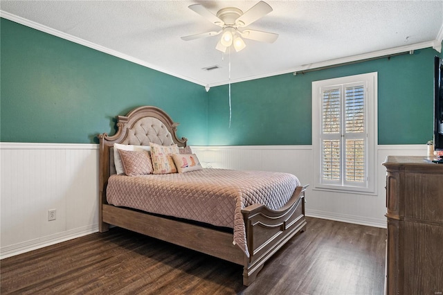 bedroom with a textured ceiling, wood finished floors, and wainscoting