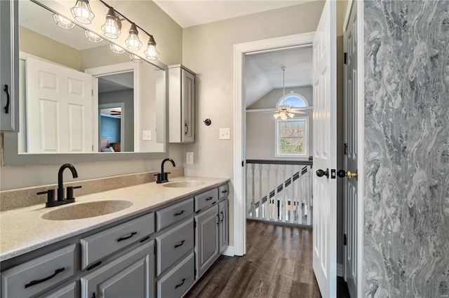 bathroom featuring ceiling fan, double vanity, wood finished floors, and a sink