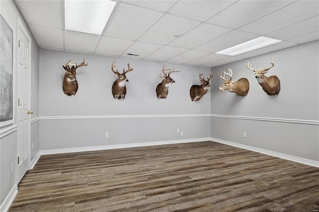 unfurnished room featuring a drop ceiling, baseboards, visible vents, and wood finished floors