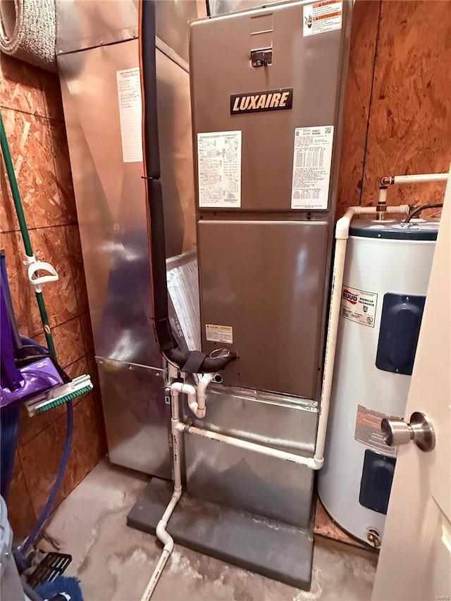 utility room with heating unit and electric water heater