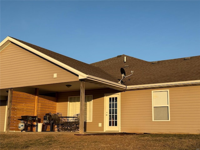 rear view of house with a shingled roof