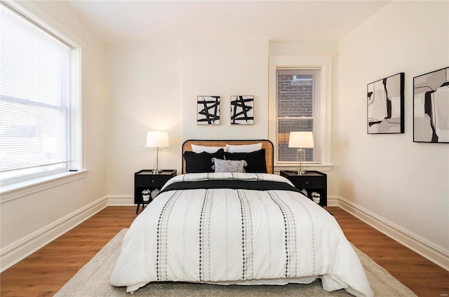 bedroom featuring baseboards and wood finished floors