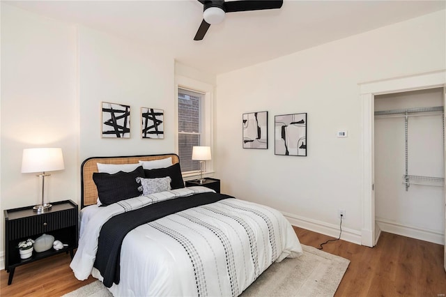 bedroom with a ceiling fan, baseboards, and wood finished floors