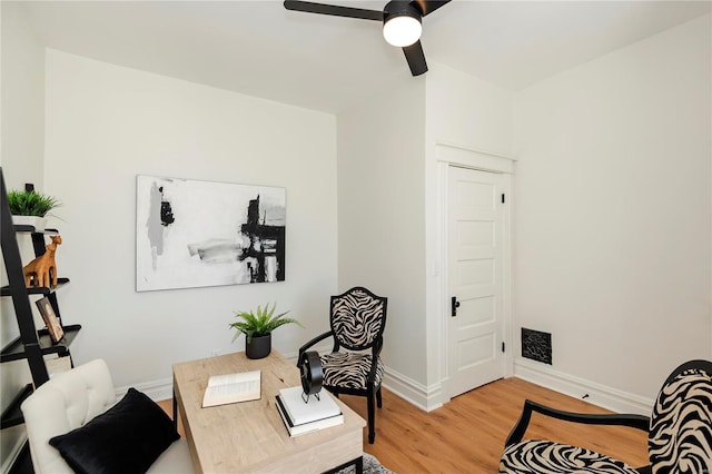 office space with baseboards, light wood-style flooring, and a ceiling fan