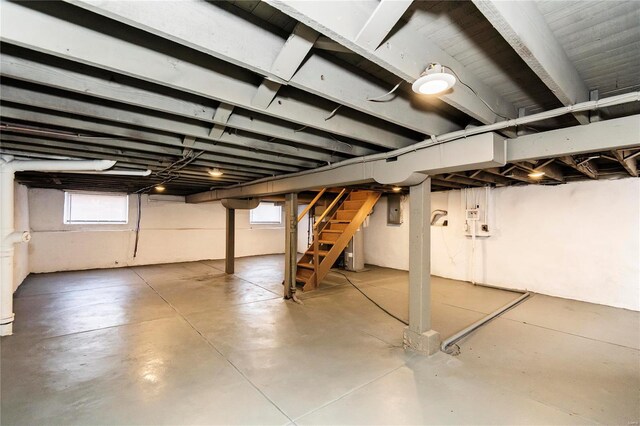 basement featuring electric panel and stairway