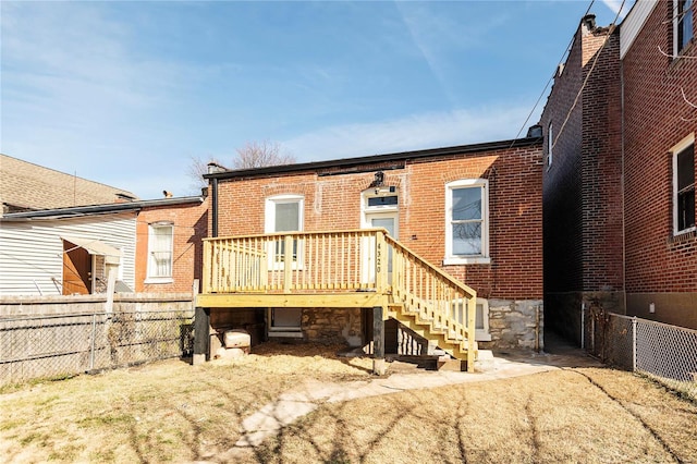 back of property with brick siding, stairway, a deck, and fence