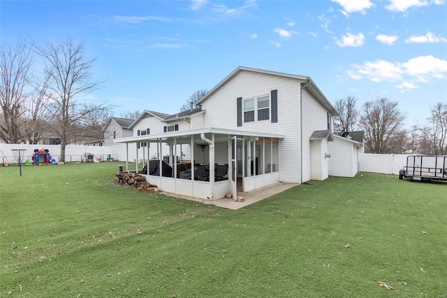 back of property with a lawn, a fenced backyard, and a sunroom