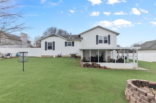 back of house featuring an outdoor fire pit, a sunroom, a fenced backyard, and a lawn