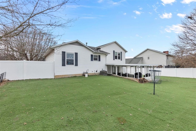 back of property with a fenced backyard and a yard