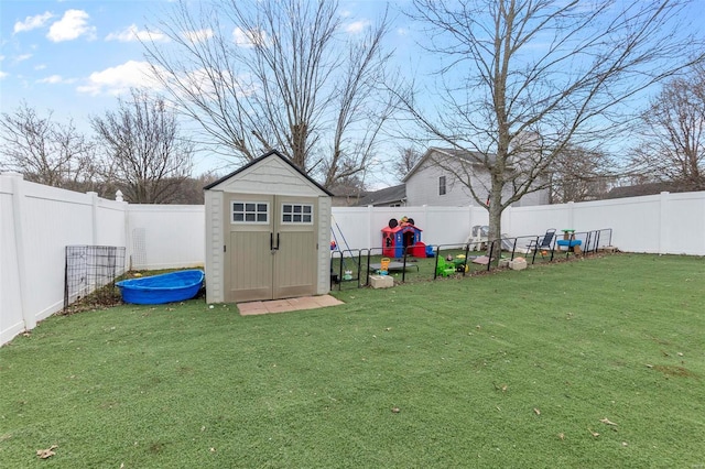 view of yard featuring a shed, an outdoor structure, and a fenced backyard