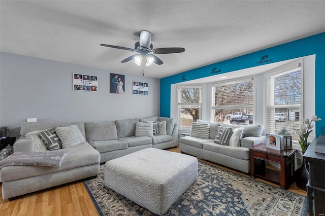 living room featuring plenty of natural light, a textured ceiling, and wood finished floors