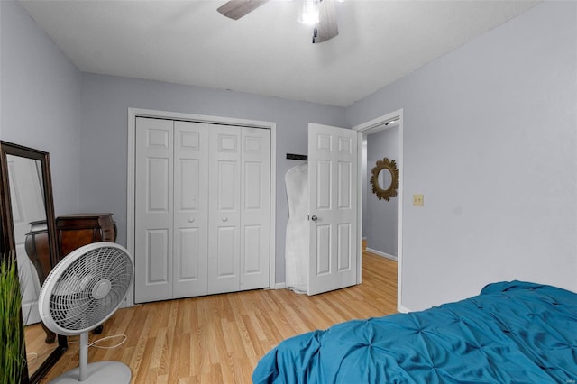 bedroom featuring ceiling fan, a closet, light wood-type flooring, and baseboards