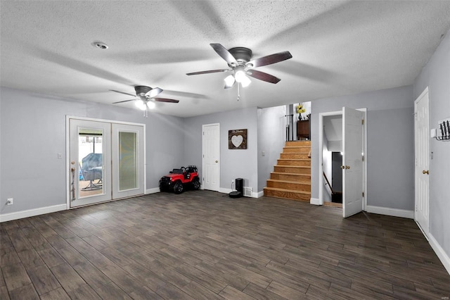 unfurnished living room with dark wood-style floors, stairway, baseboards, and a textured ceiling