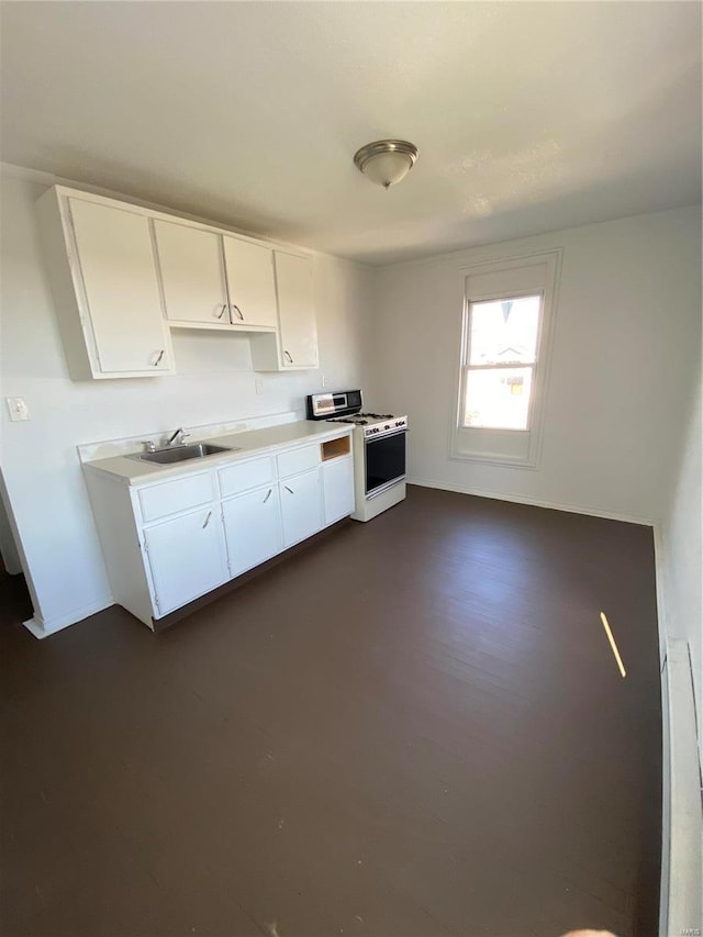 kitchen featuring white cabinetry, light countertops, and gas range gas stove