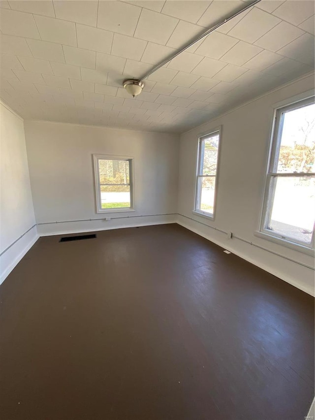 empty room featuring visible vents and baseboards