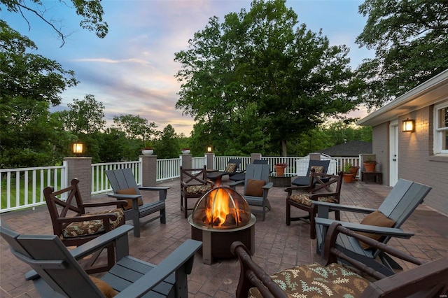 patio terrace at dusk featuring a fire pit