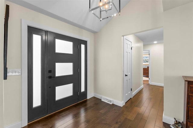 foyer featuring lofted ceiling, dark wood-style flooring, visible vents, and baseboards