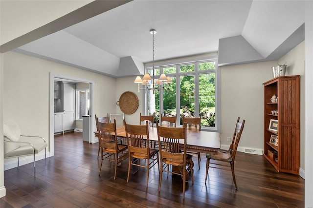 dining room featuring lofted ceiling, dark wood-style floors, baseboards, and a chandelier