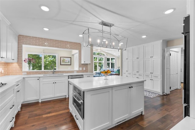 kitchen featuring light countertops, plenty of natural light, a sink, and a center island