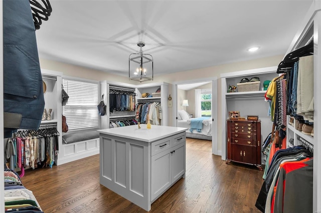 walk in closet featuring dark wood-style floors and a notable chandelier