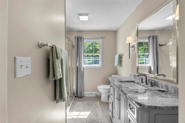 bathroom with curtained shower, toilet, vanity, visible vents, and baseboards