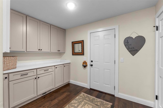 washroom with baseboards and dark wood finished floors