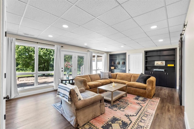 living room with recessed lighting, visible vents, and wood finished floors