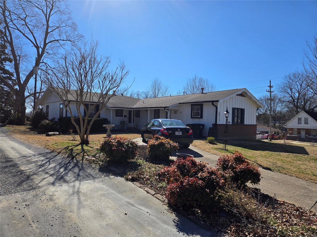 ranch-style home featuring driveway and a front lawn