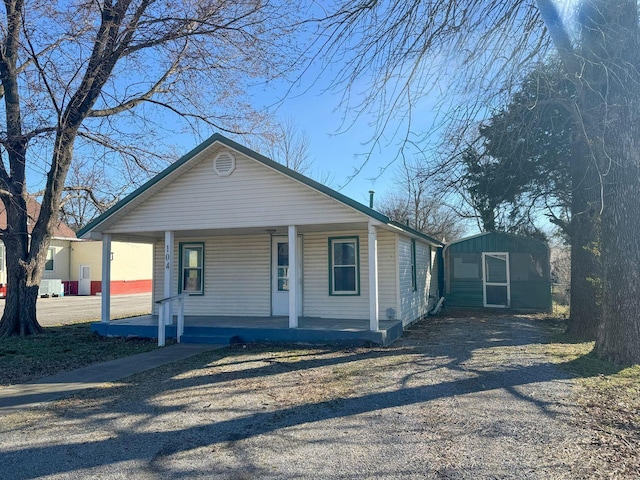 bungalow-style house featuring an outbuilding and a porch