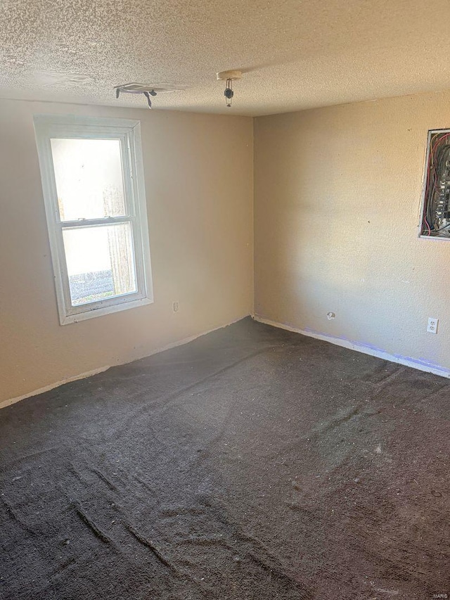 spare room with a textured ceiling and carpet floors