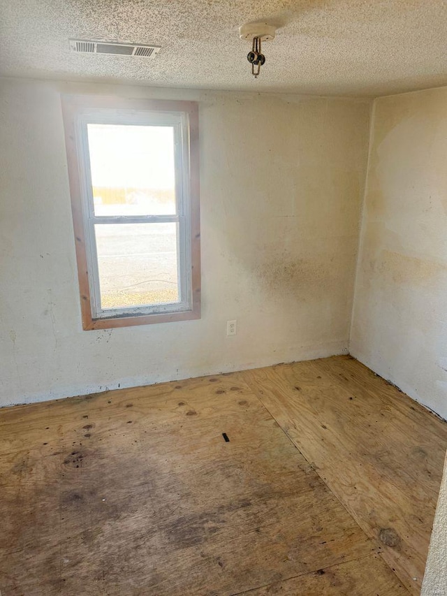 unfurnished room featuring visible vents and a textured ceiling