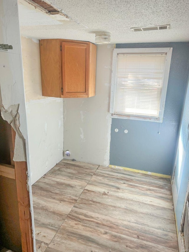 washroom with visible vents and a textured ceiling