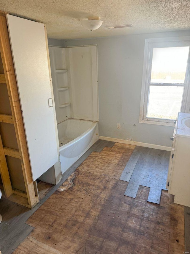 full bathroom with bathtub / shower combination, baseboards, a textured ceiling, and vanity