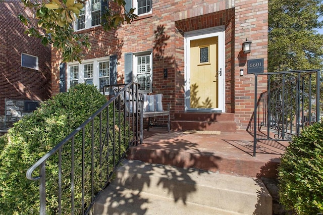 view of exterior entry featuring brick siding