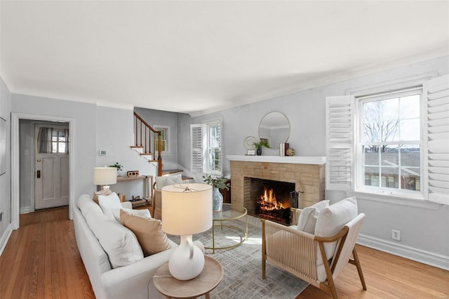 living area with a healthy amount of sunlight, stairs, and wood finished floors