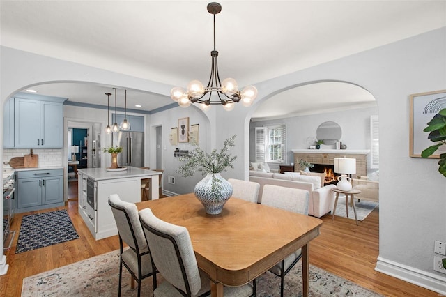 dining space with a fireplace and light wood finished floors