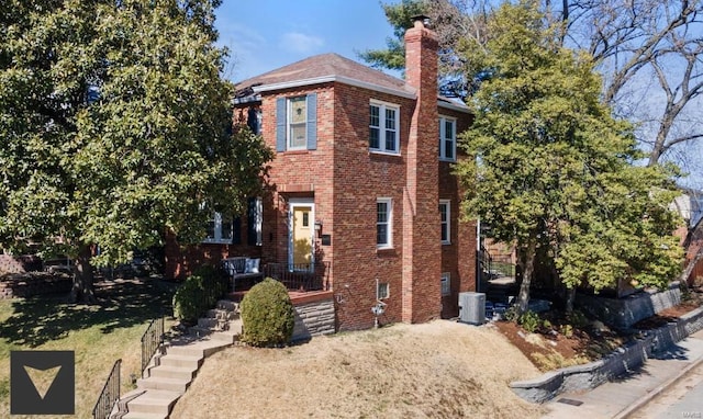 exterior space with brick siding, central AC unit, and a chimney