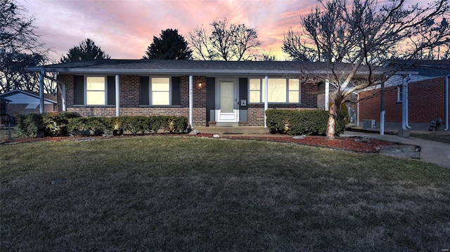 single story home with brick siding, a front yard, and cooling unit